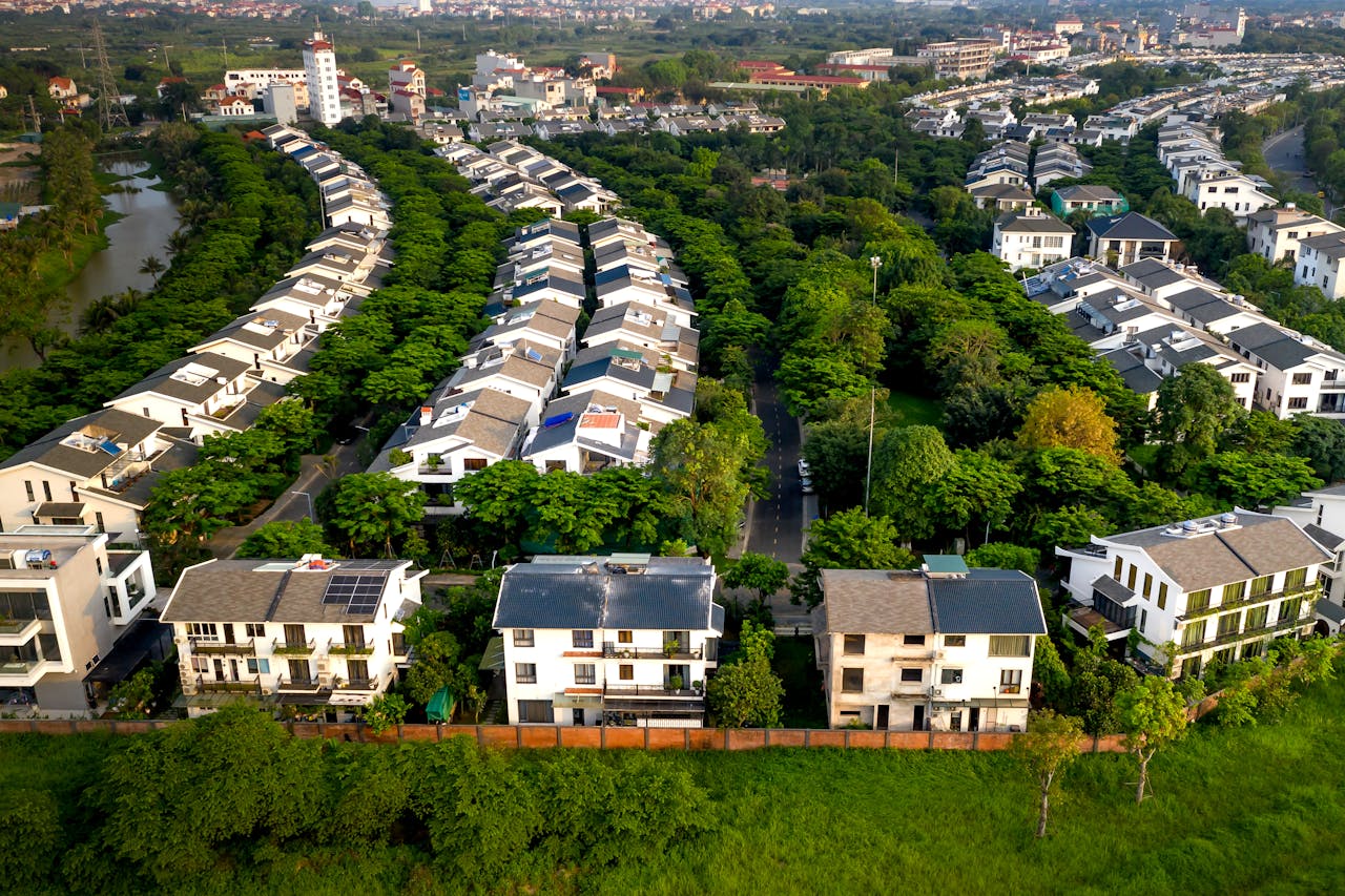 A stunning aerial view showcasing green trees and housing in a peaceful residential area.