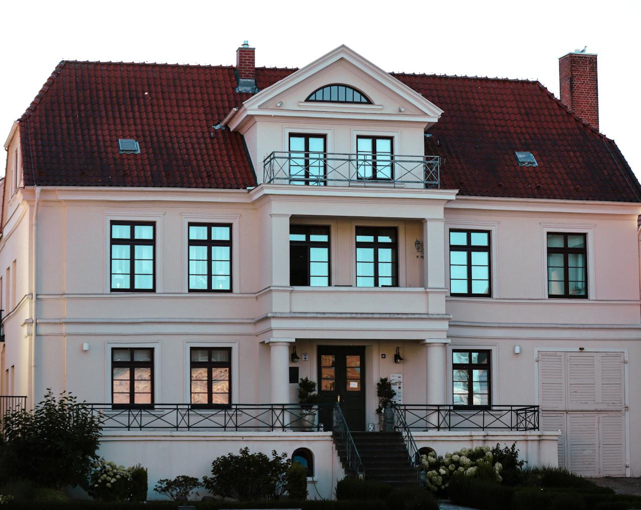 A beautiful mansion with a red tiled roof and elegant architectural design.